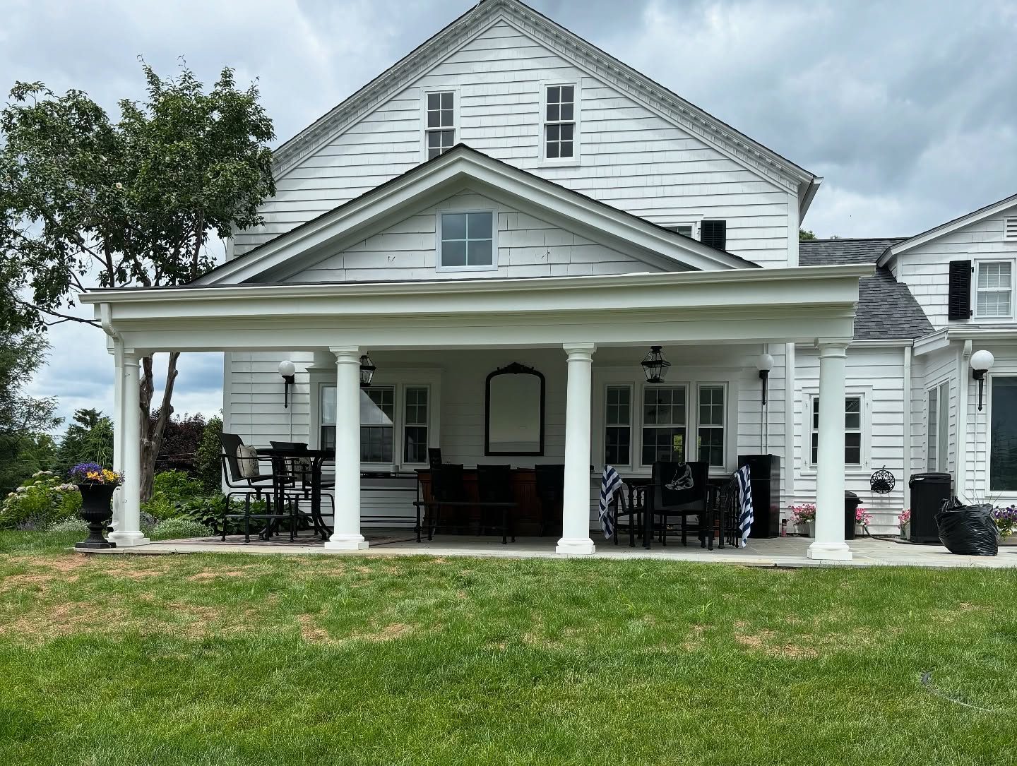 Home with a covered rear porch and white columns added on Long Island