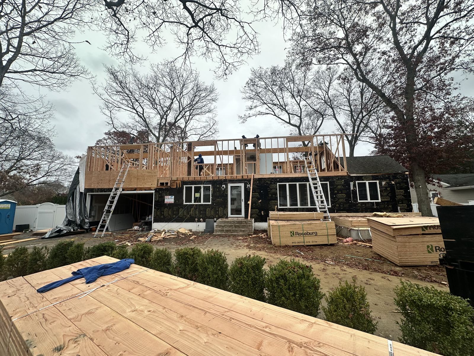Second-story dormer addition under construction, with new framing raised over the existing first floor on a Long Island home